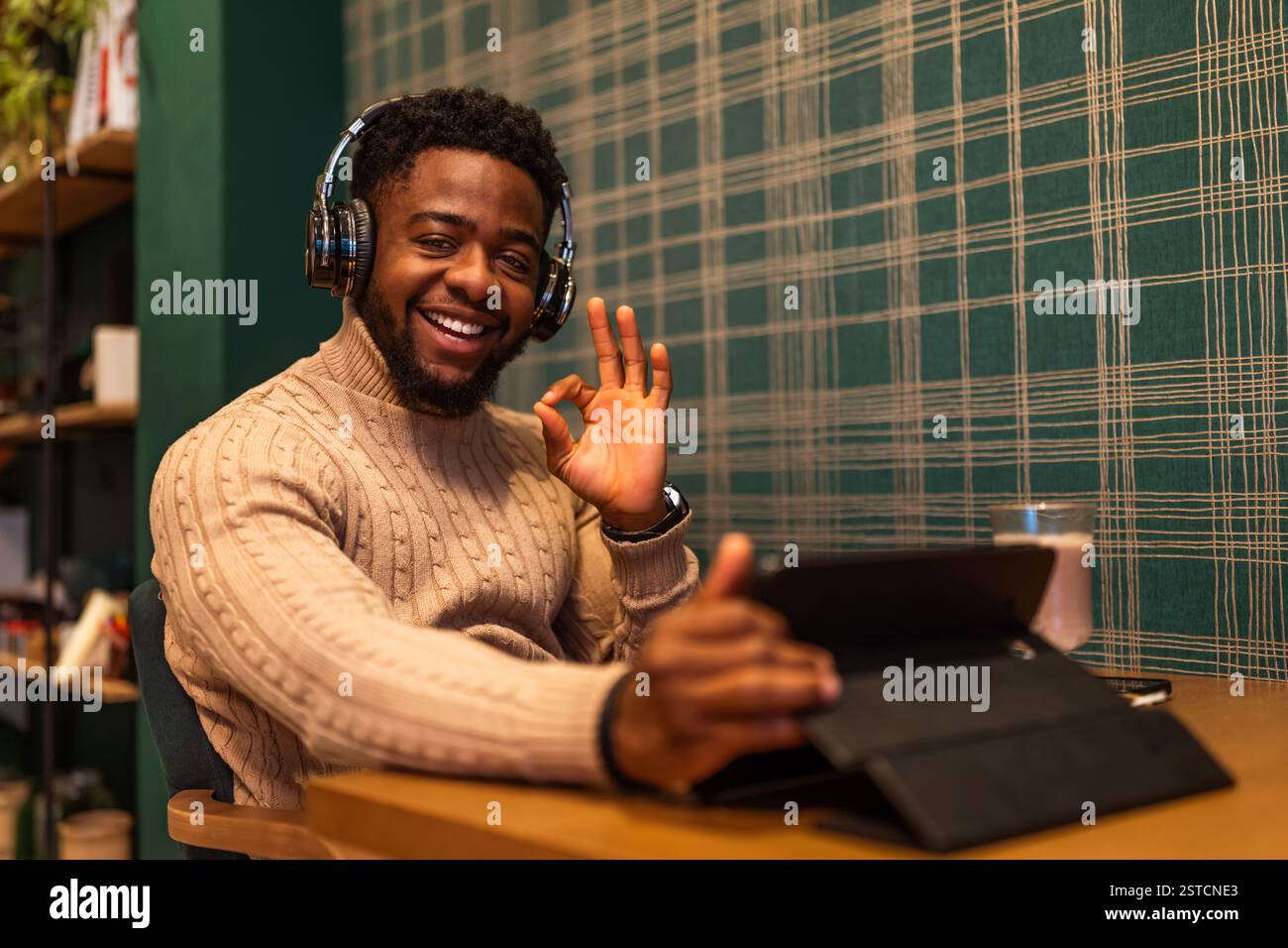 Freelancer using digital tablet to communicate online. He is sitting in bar and having video call. Stock Photo