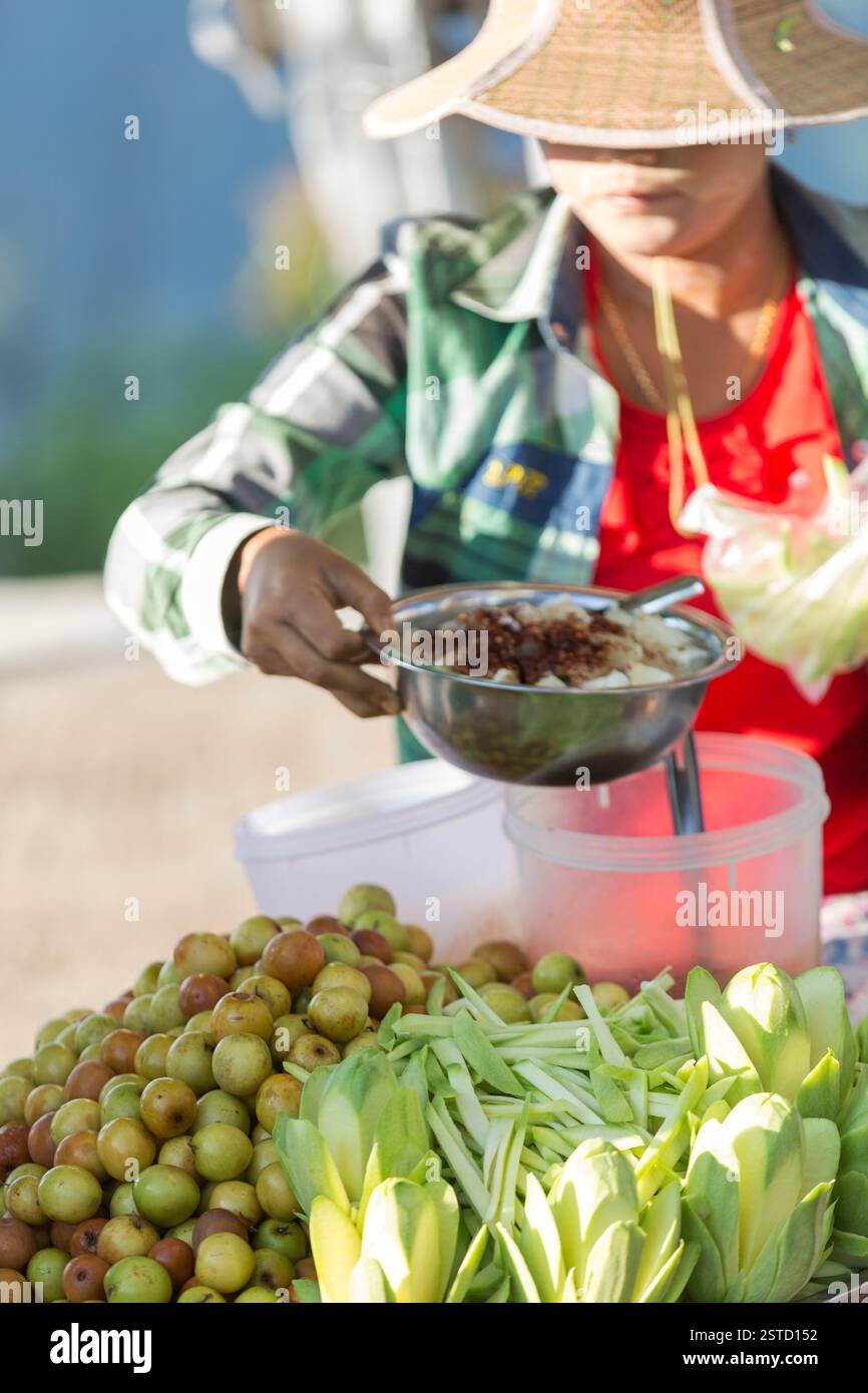 Myanmar, Kyaiktiyo Pagoda, vendor selling food on the way up to the Golden Rock. Stock Photo