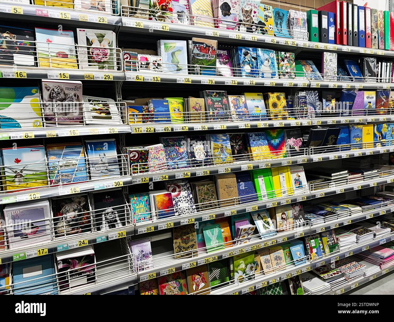 Lviv, Ukraine - February 16, 2025: Variety of notebooks and stationery items displayed on a shelf in a store. Stock Photo