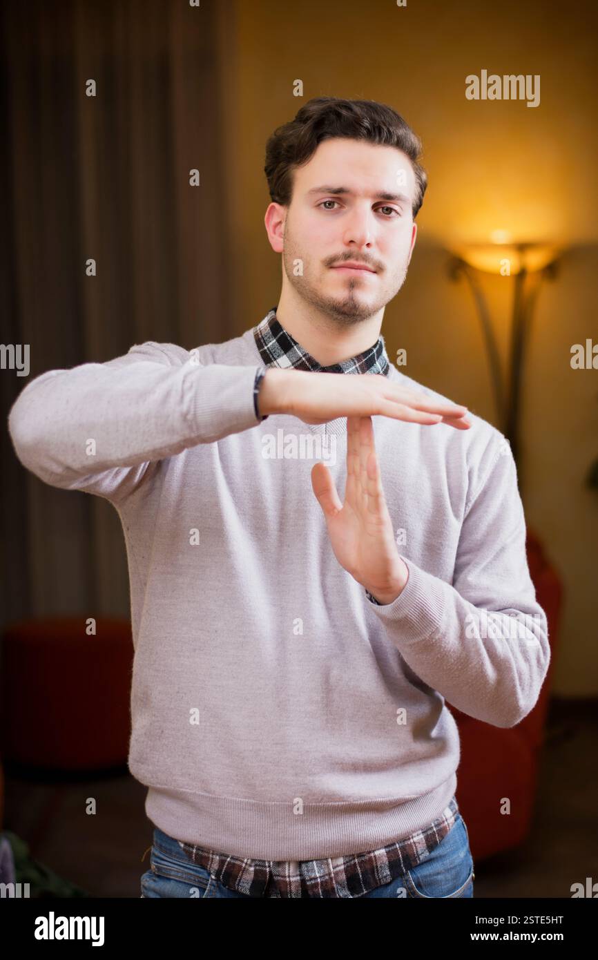 Attractive young man doing time-out sign Stock Photo - Alamy