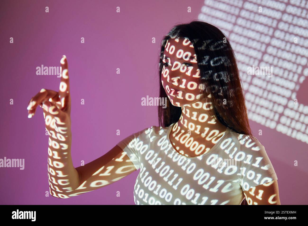 Binary machine code. Beautiful young woman is in projector neon lights in the studio. Stock Photo