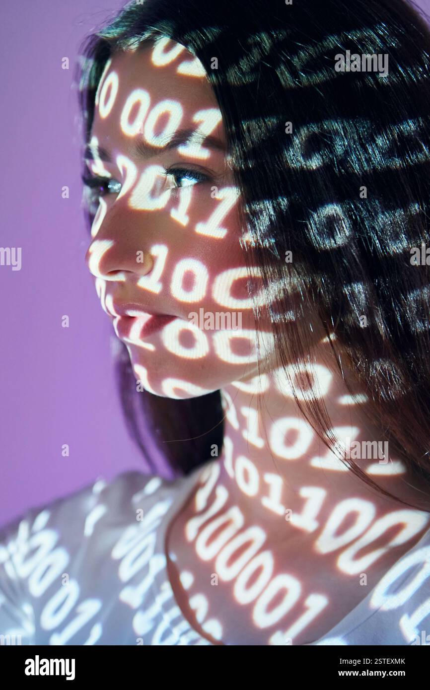 Binary machine code. Beautiful young woman is in projector neon lights in the studio. Stock Photo