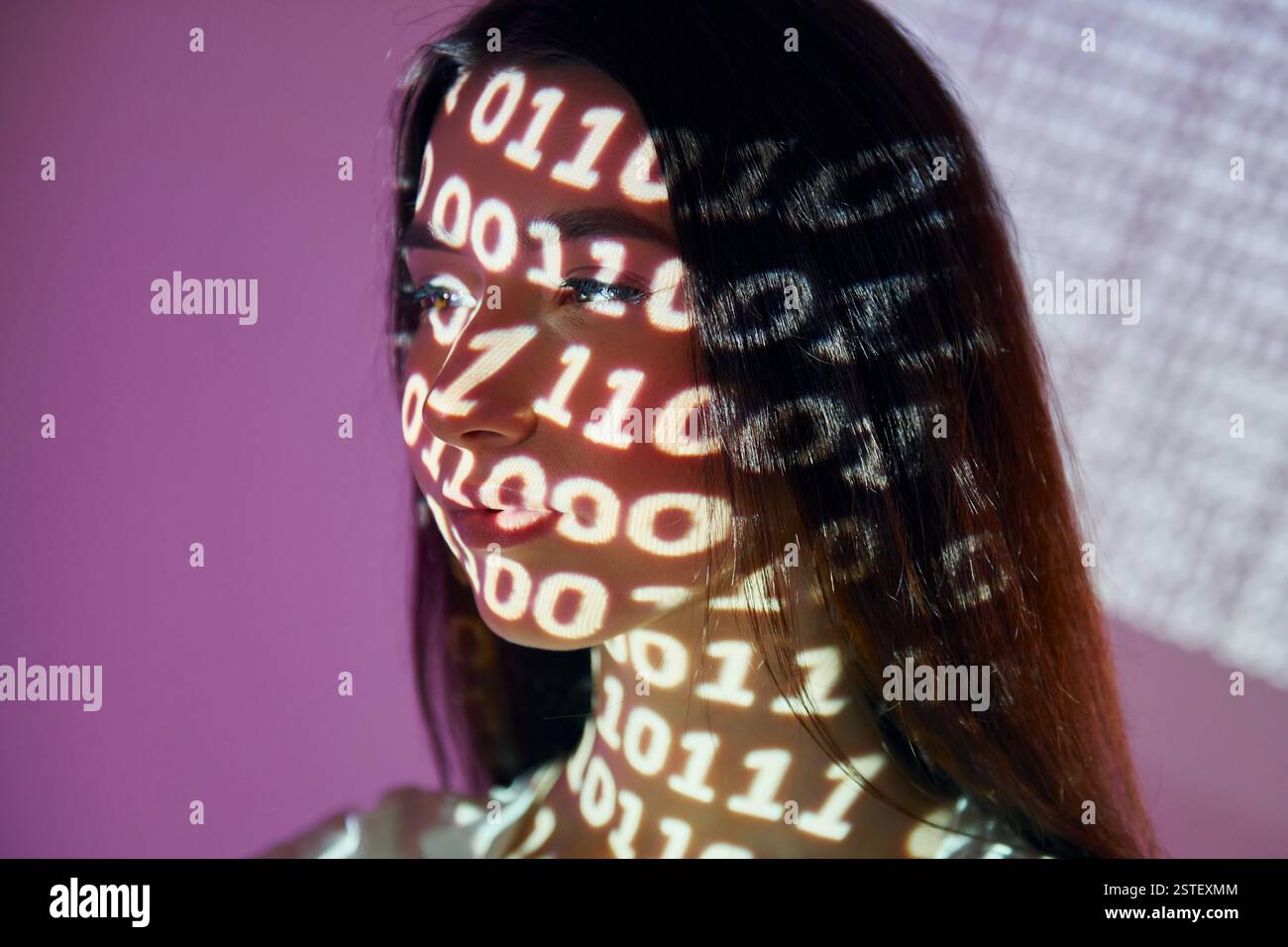Binary machine code. Beautiful young woman is in projector neon lights in the studio. Stock Photo