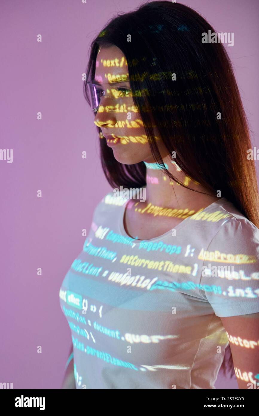 Front end programming language's scripts. Beautiful young woman is in projector neon lights in the studio. Stock Photo