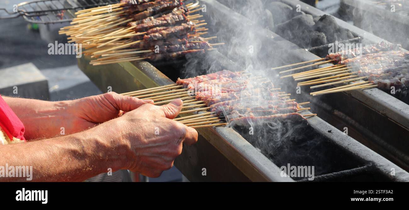 European Cook Large hands of the shepherd cooking ARROSTICINI, a typical dish of ...