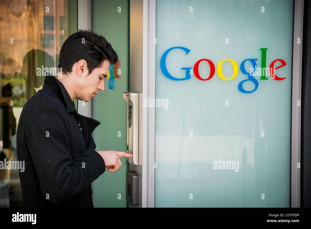 Man ringing the intercom at Google offices Stock Photo