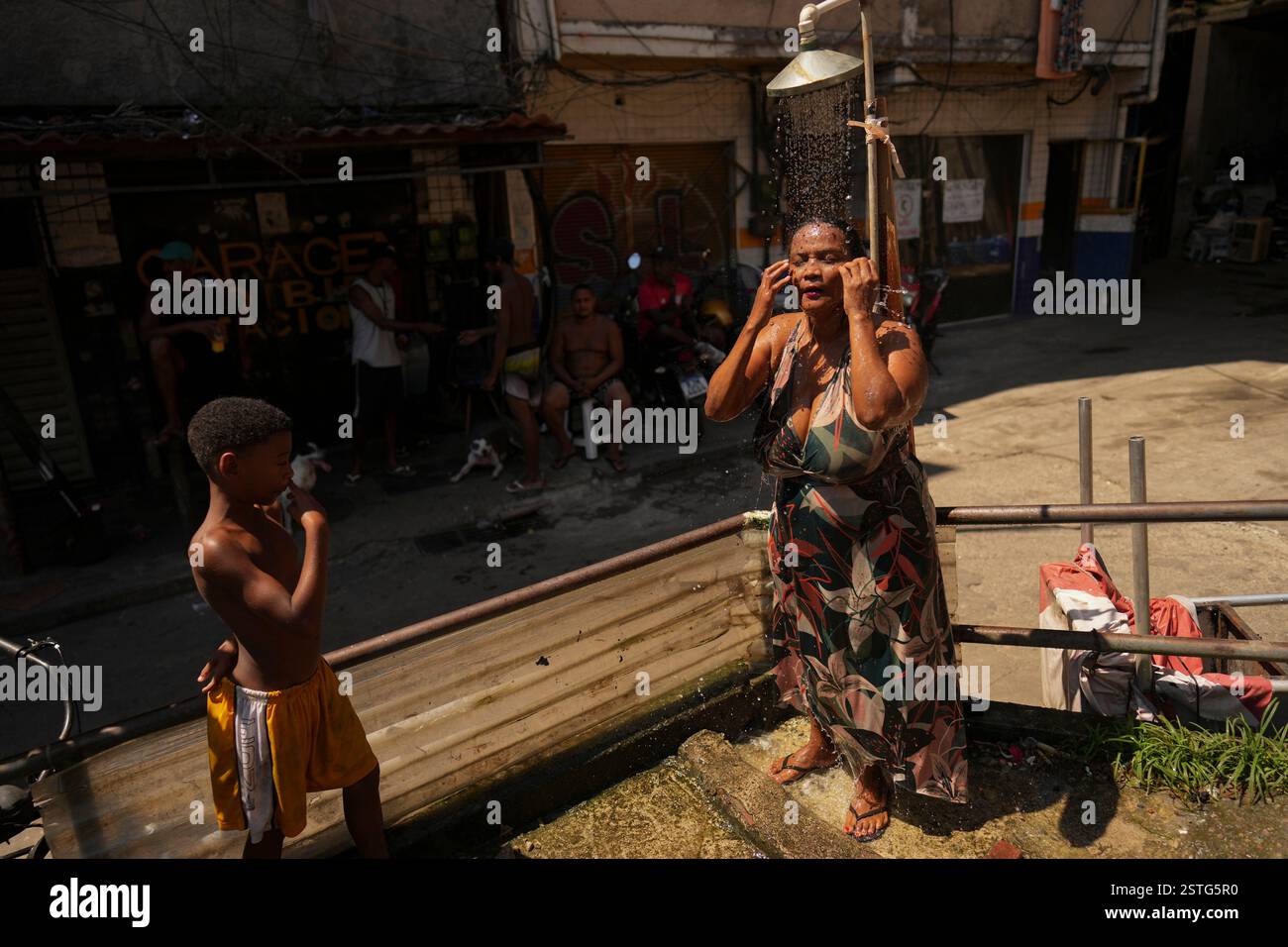 Rio Cools A woman cools off in a public shower during summer in the Rocinha ...