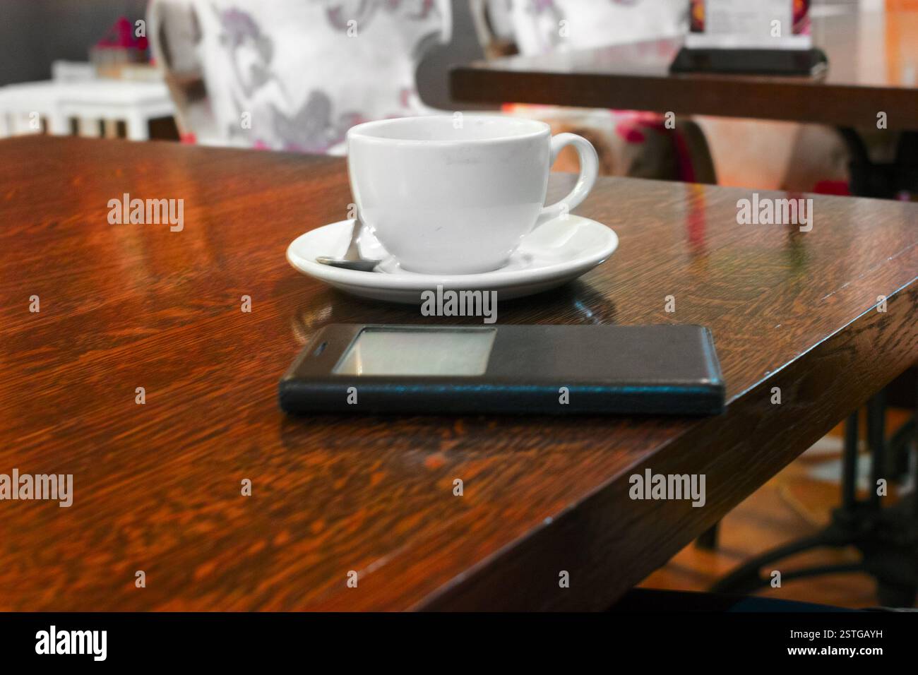 Cup of tea and smartphone on the polished wooden table, copyspace. Stock Photo