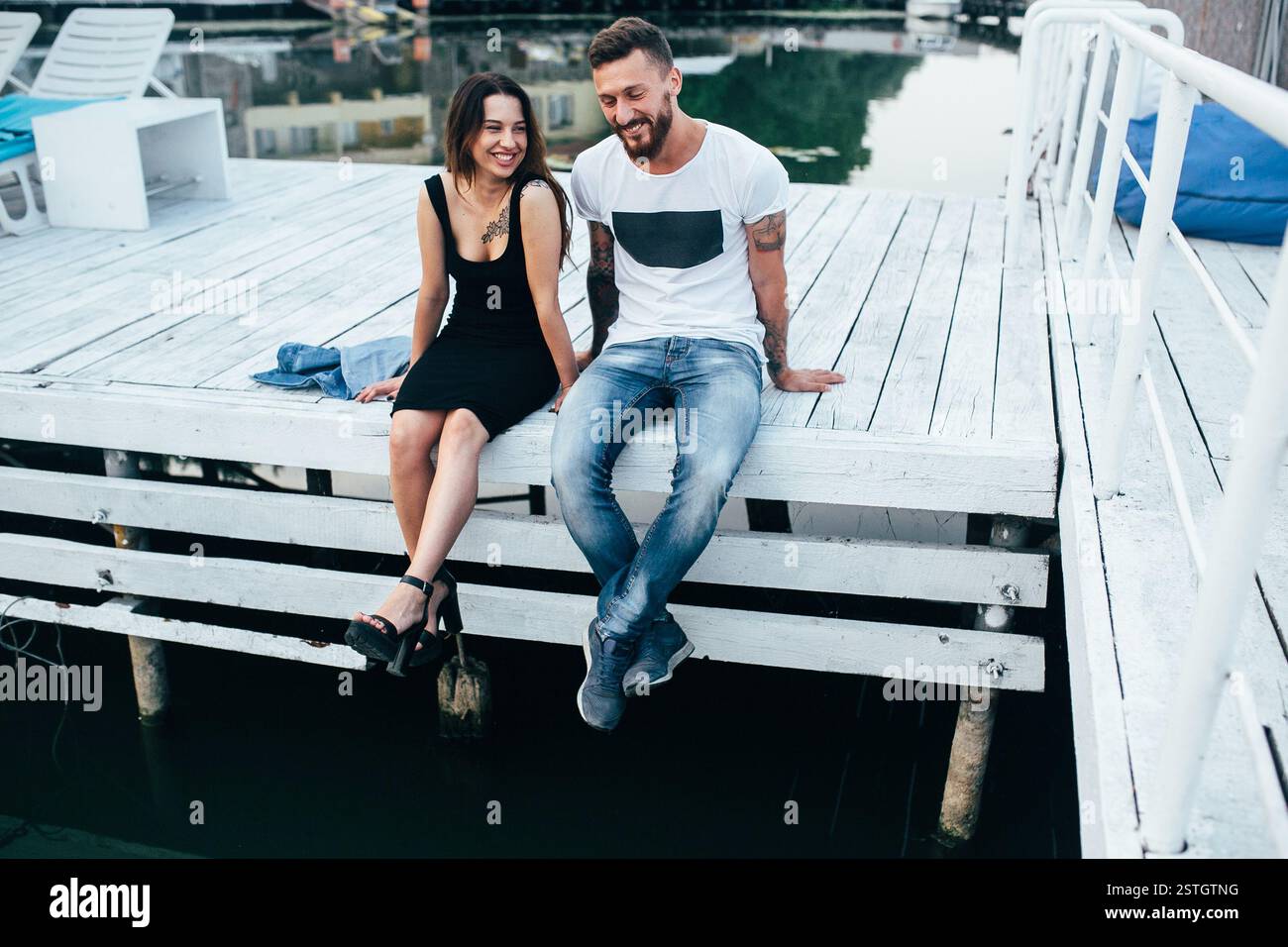 beautiful couple posing on a wooden pier at lake Stock Photo - Alamy
