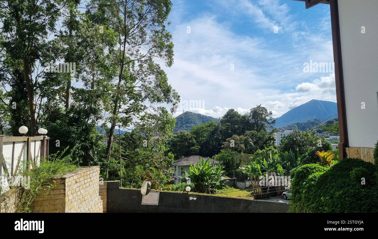 This charming European-style house is nestled at the foot of a lush, green hill, blending nature and architecture beautifully. - Smartphone Captured Stock Image
