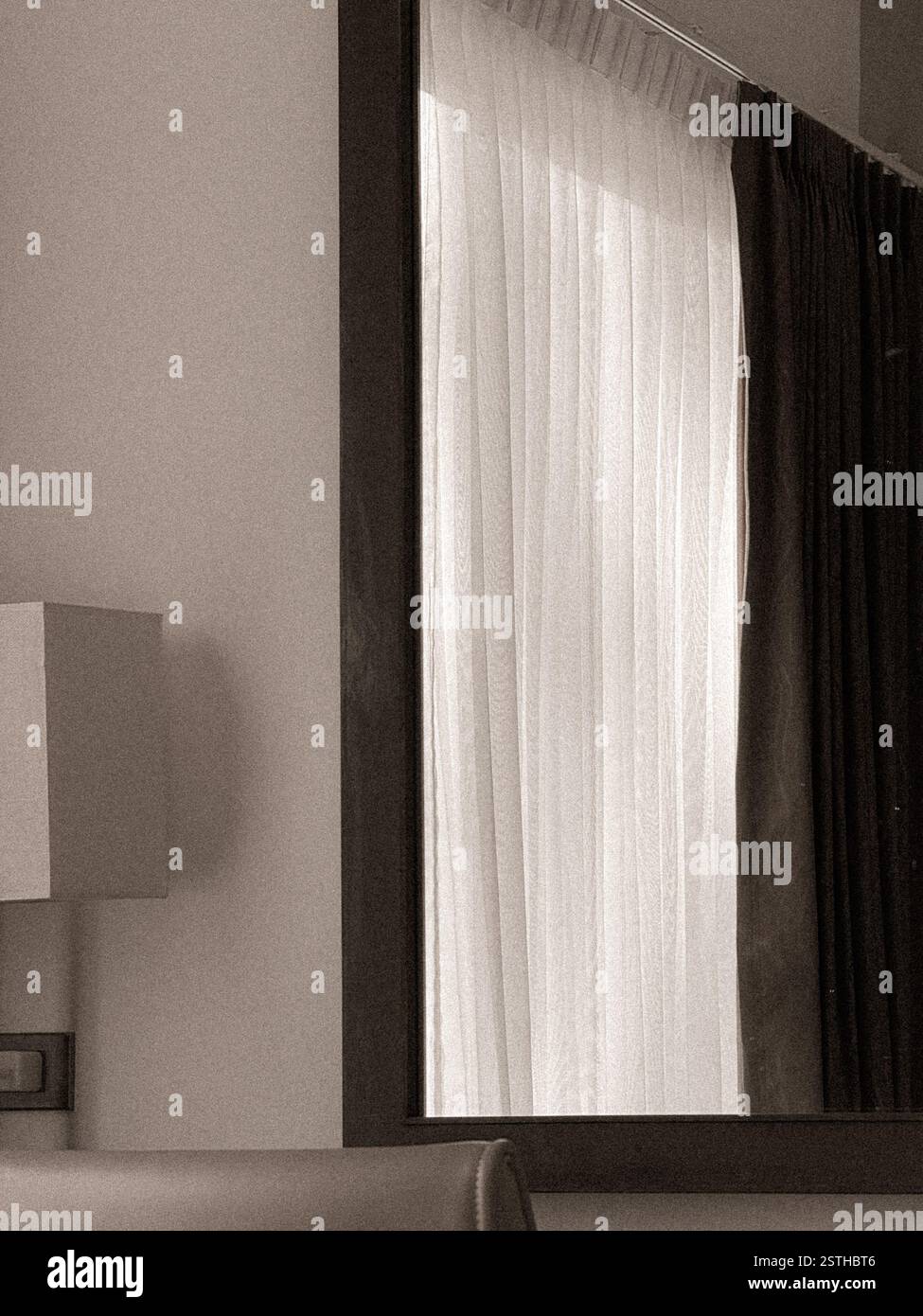 Hotel room with window, curtains, and soft lighting Interior of a hotel room featuring a large window with sheer white curtains that allow soft light - Smartphone Captured Stock Image