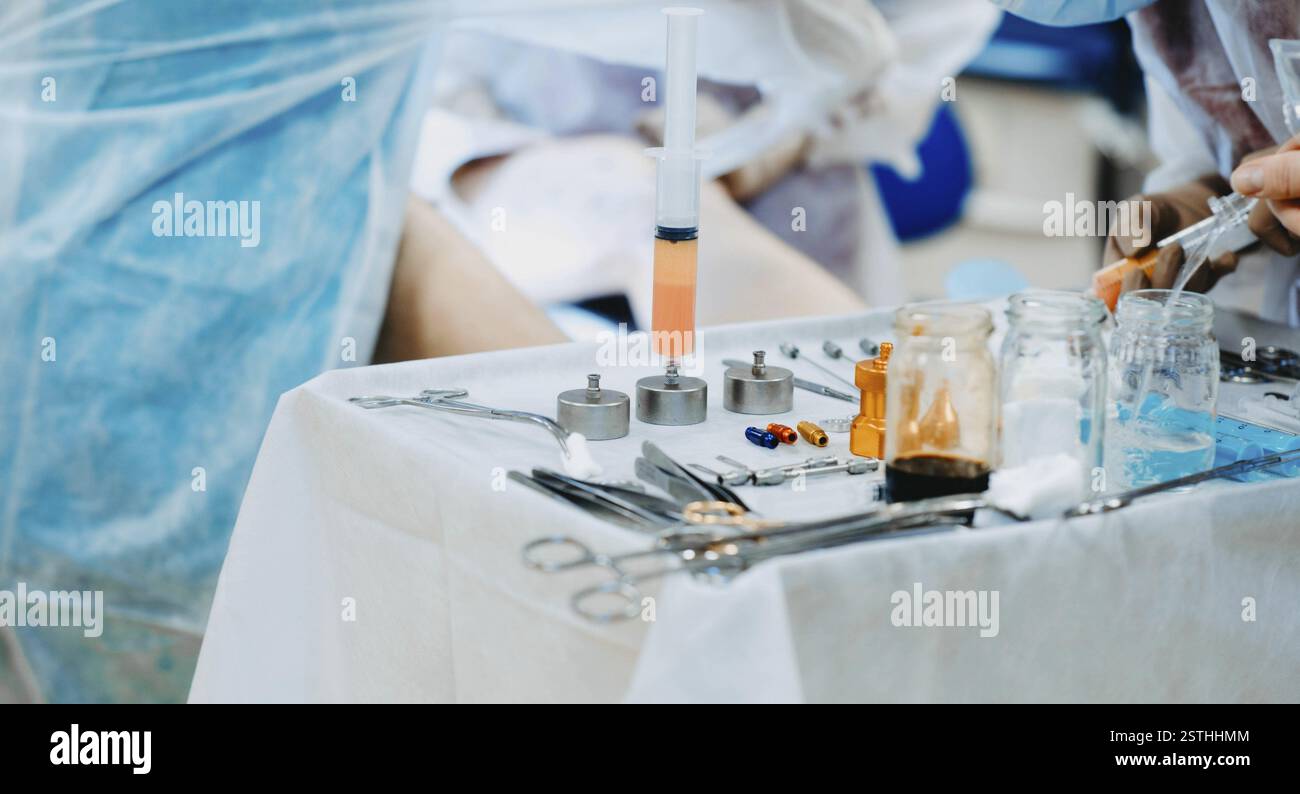 Medical professionals work with syringes and tools in a hospital's ...