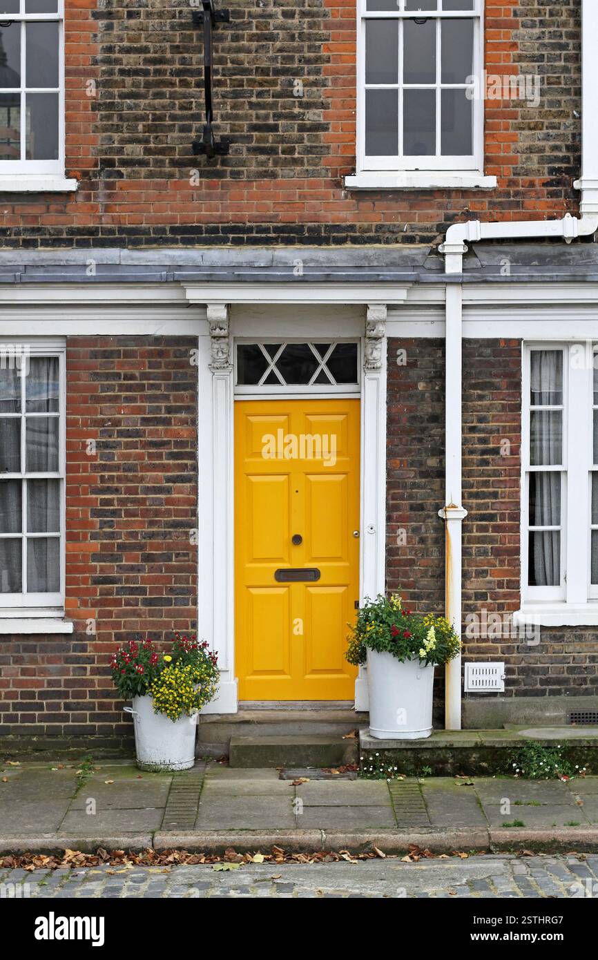 Old english house with brick wall and yellow door hi-res stock ...