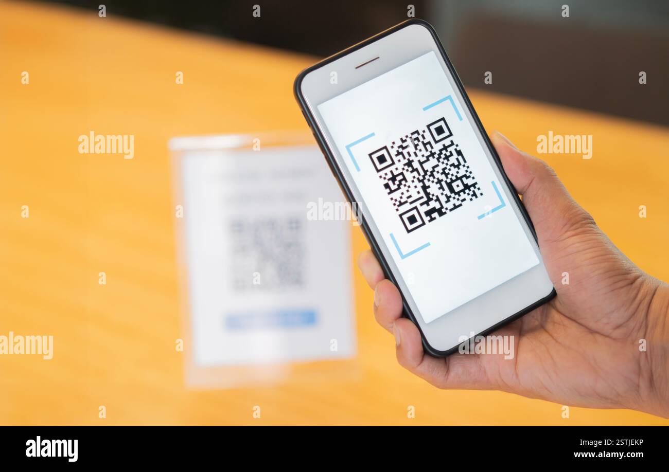 Men's hand uses a mobile phone application to scan QR codes in stores ...