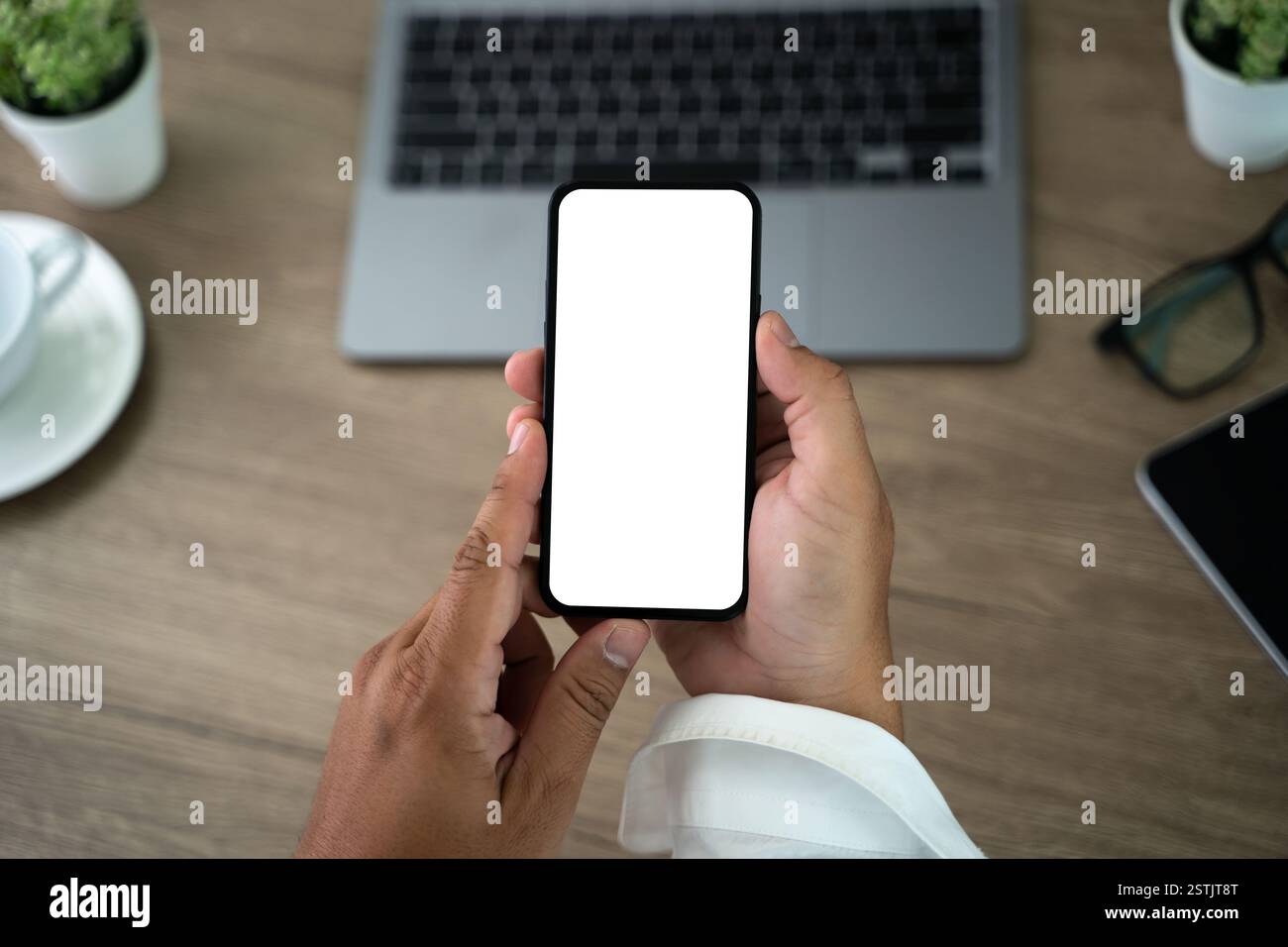 Top view Mockup image hand using a smartphone man Holding Cell Phone With Blank Screen Stock Photo