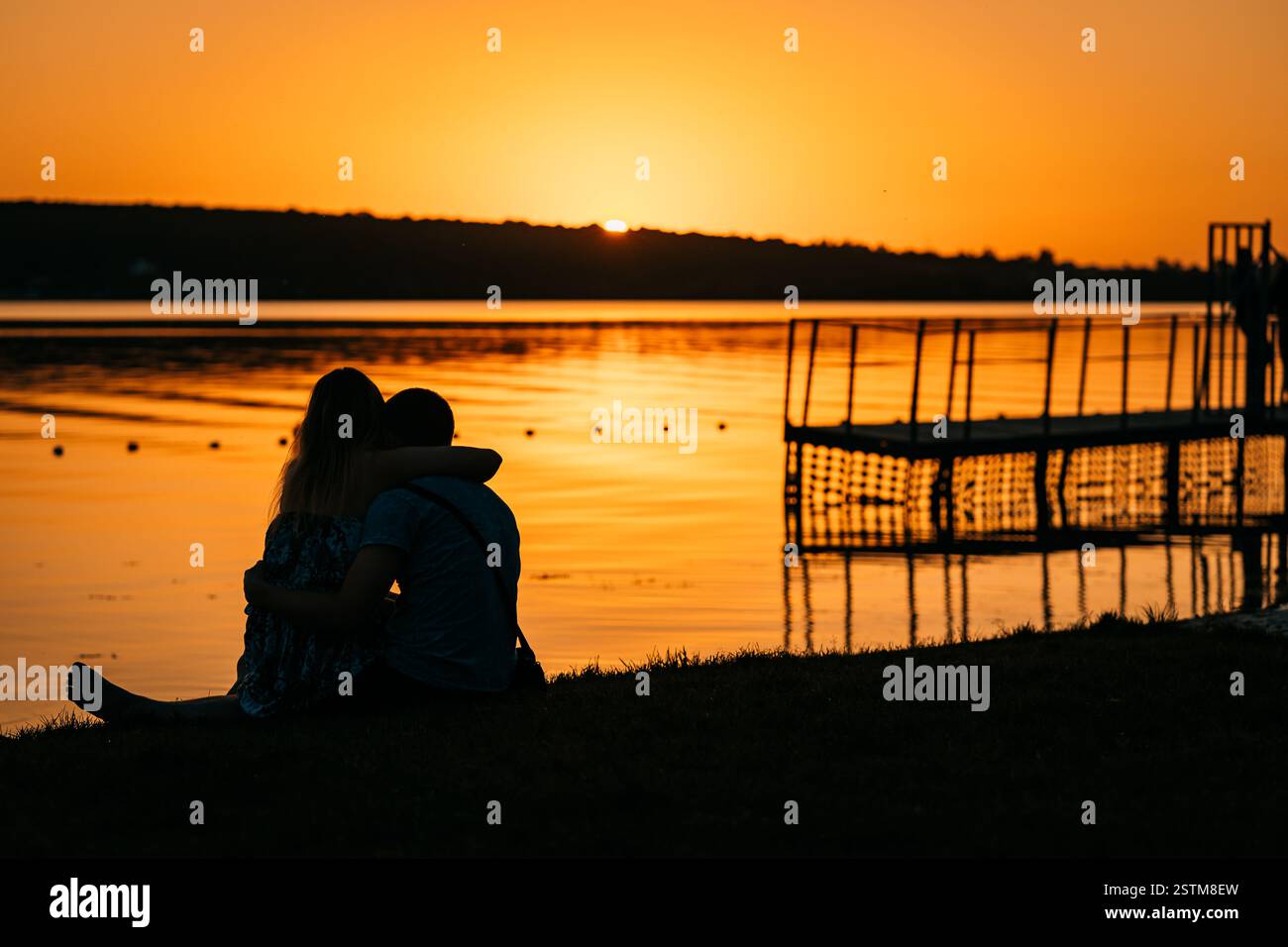Young couple resting on the river bank Stock Photo