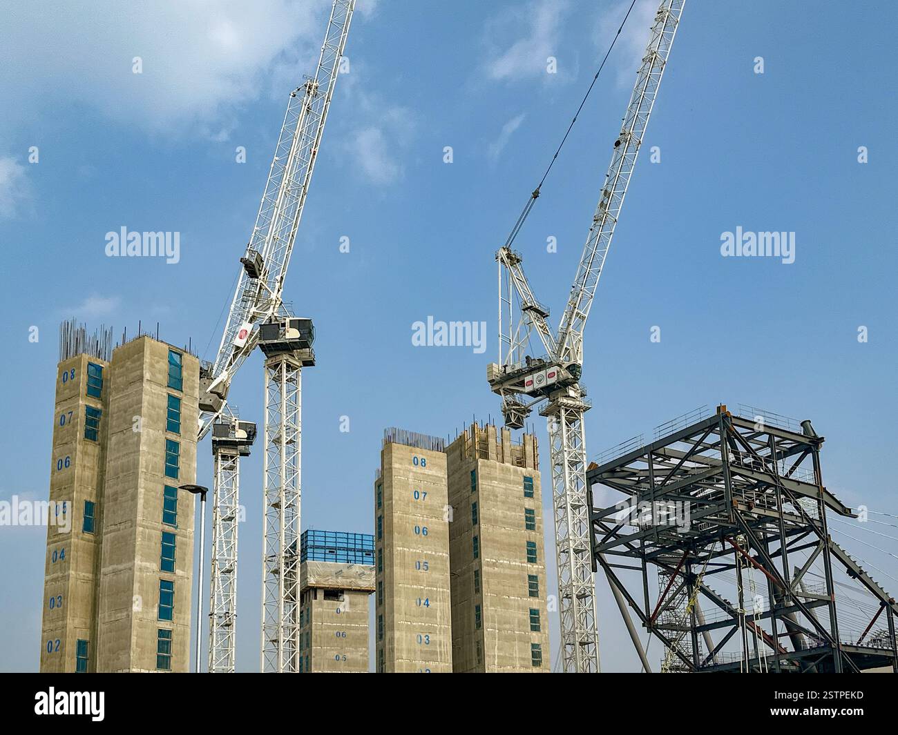 Manchester, England, UK - 31 May 2024: Tower cranes working on elevator shafts for the improvement of Manchester City's football ground - Smartphone Captured Stock Image