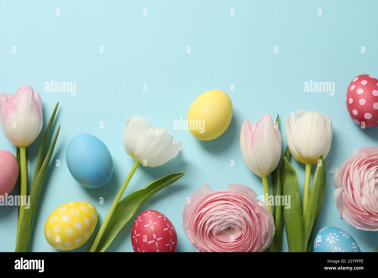 Easter eggs and beautiful spring flowers on light blue background, flat ...