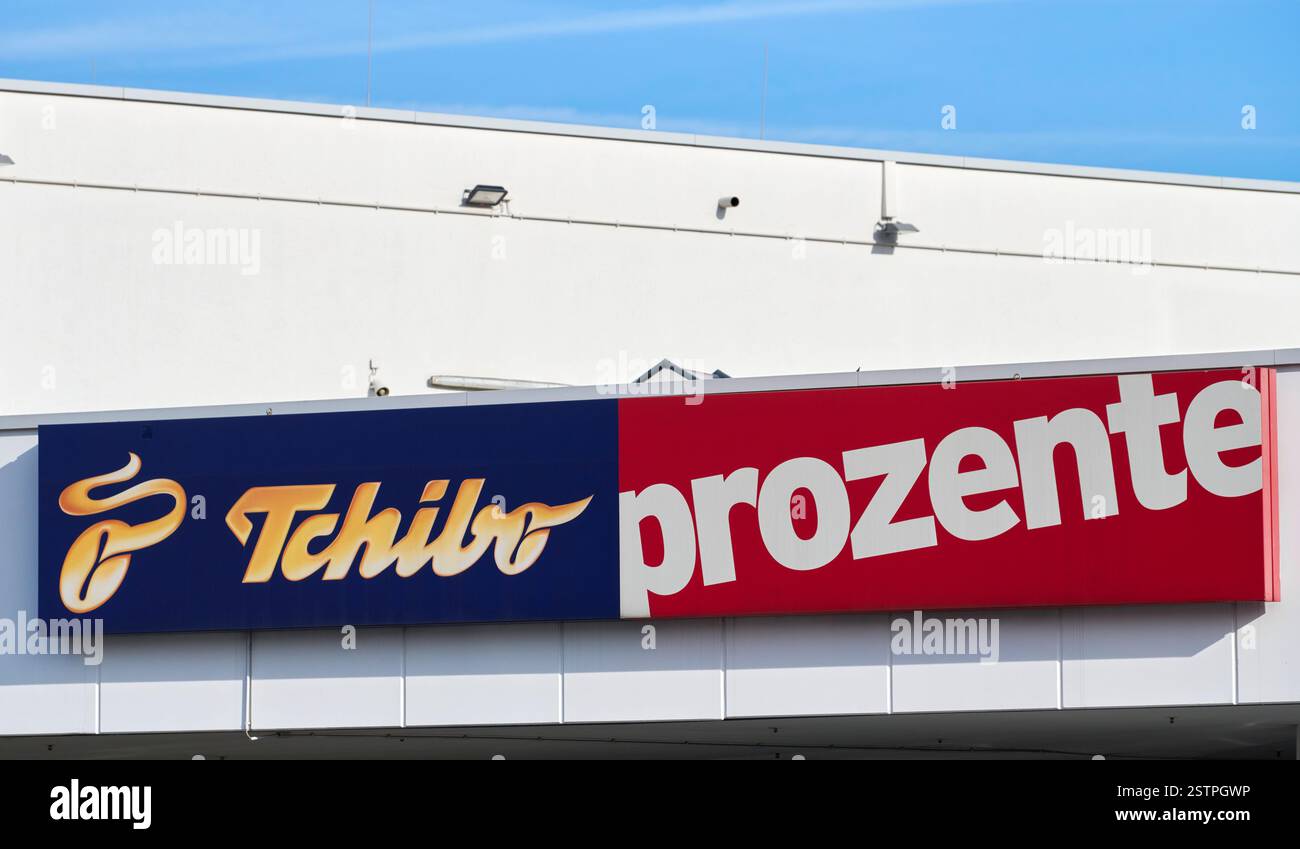 Auf einer weißen Fassade hängt ein Tchibo Logo mit dem Zusatz prozente ...