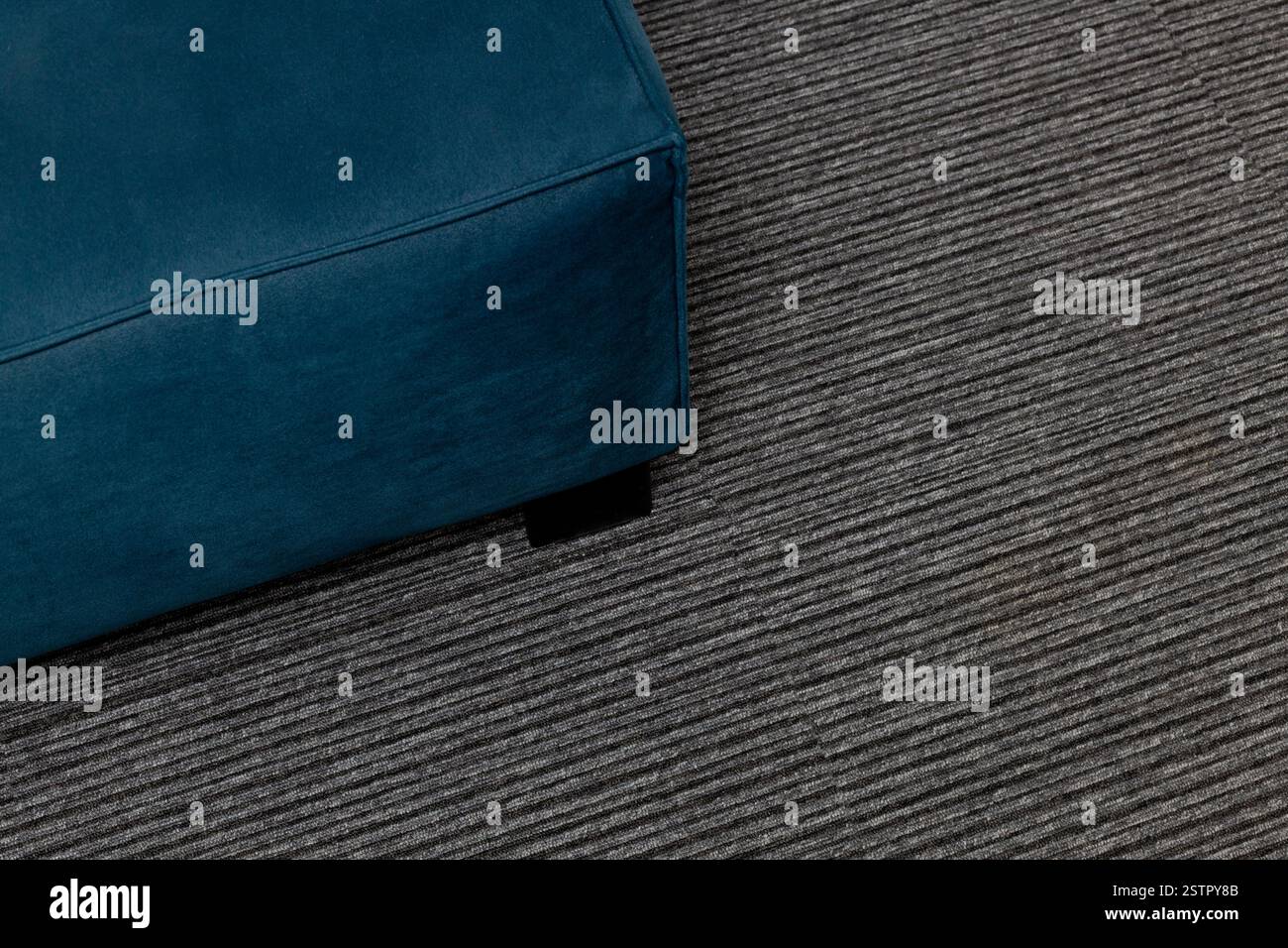 Close Up Top View of Dark Blue Sofa on Gray Carpet Stock Photo