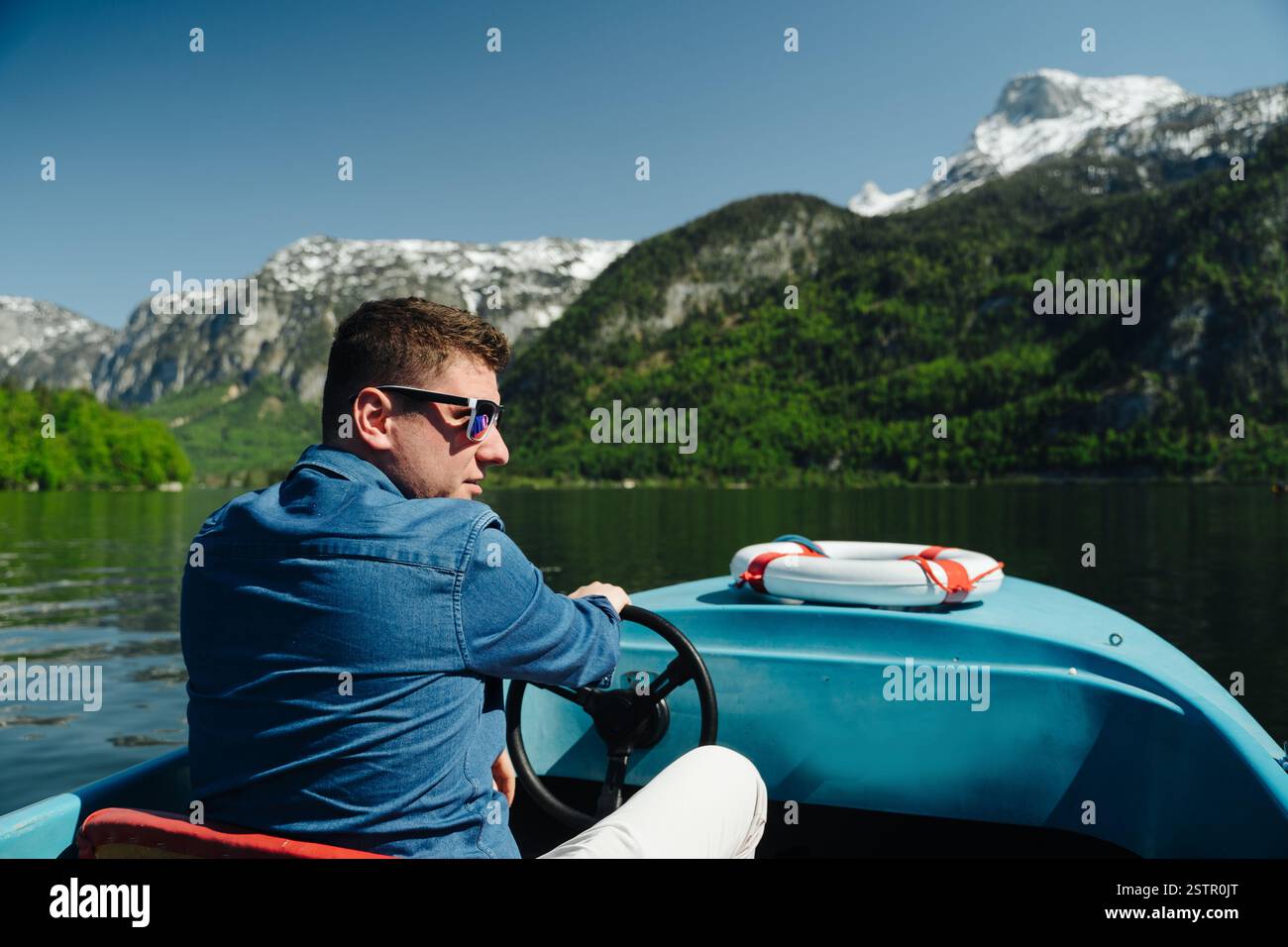 Young man steering boat hi-res stock photography and images - Alamy