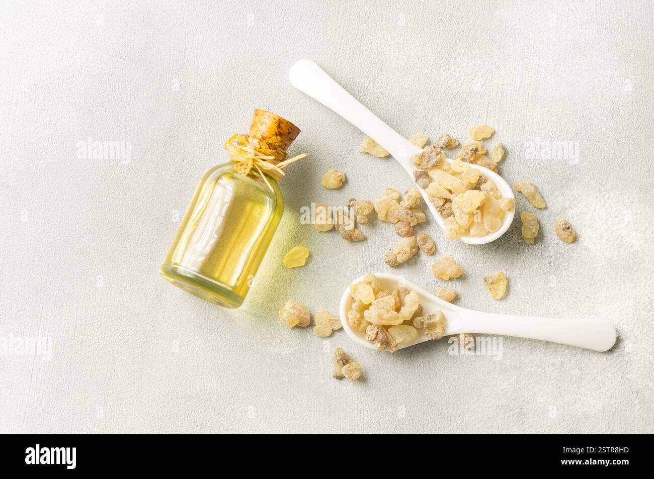 Glass bottle of frankincense essential oil with aromatic resins on rustic background, herbal medicine Stock Photo