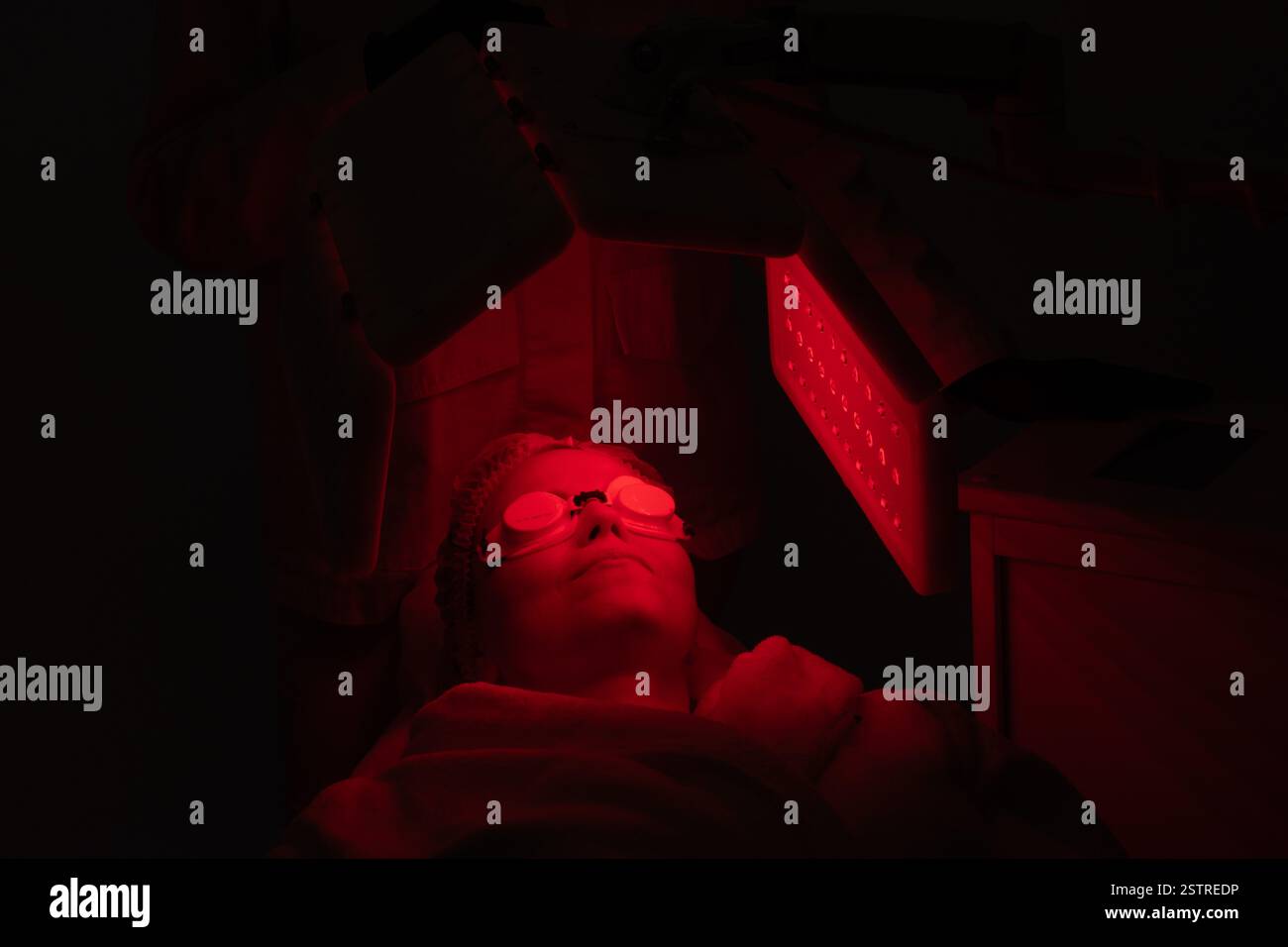 Red light therapy session in a dark treatment room with a patient ...