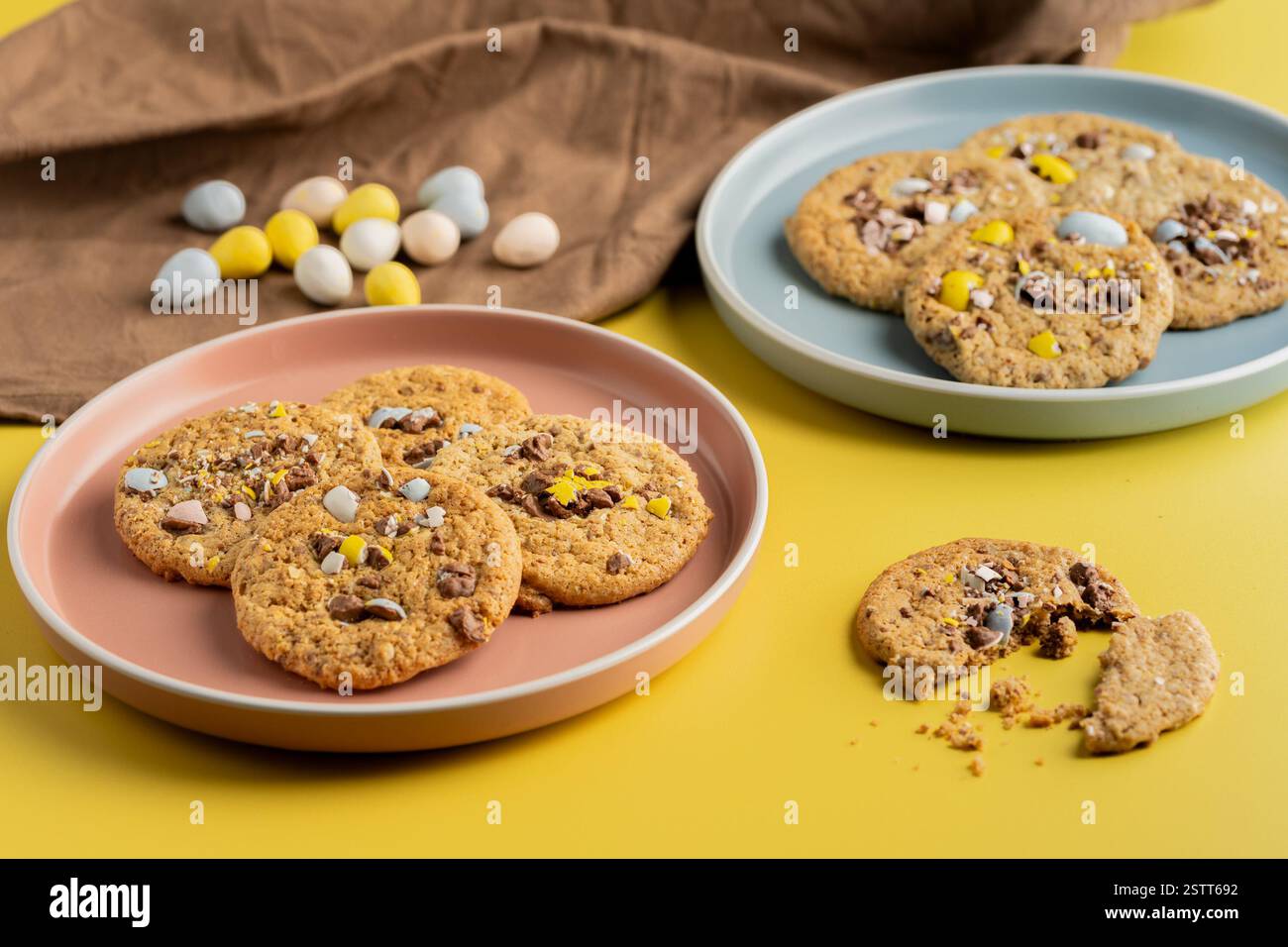Easter Candy Egg Cookies on Colorful Plates with Yellow Background Stock Photo