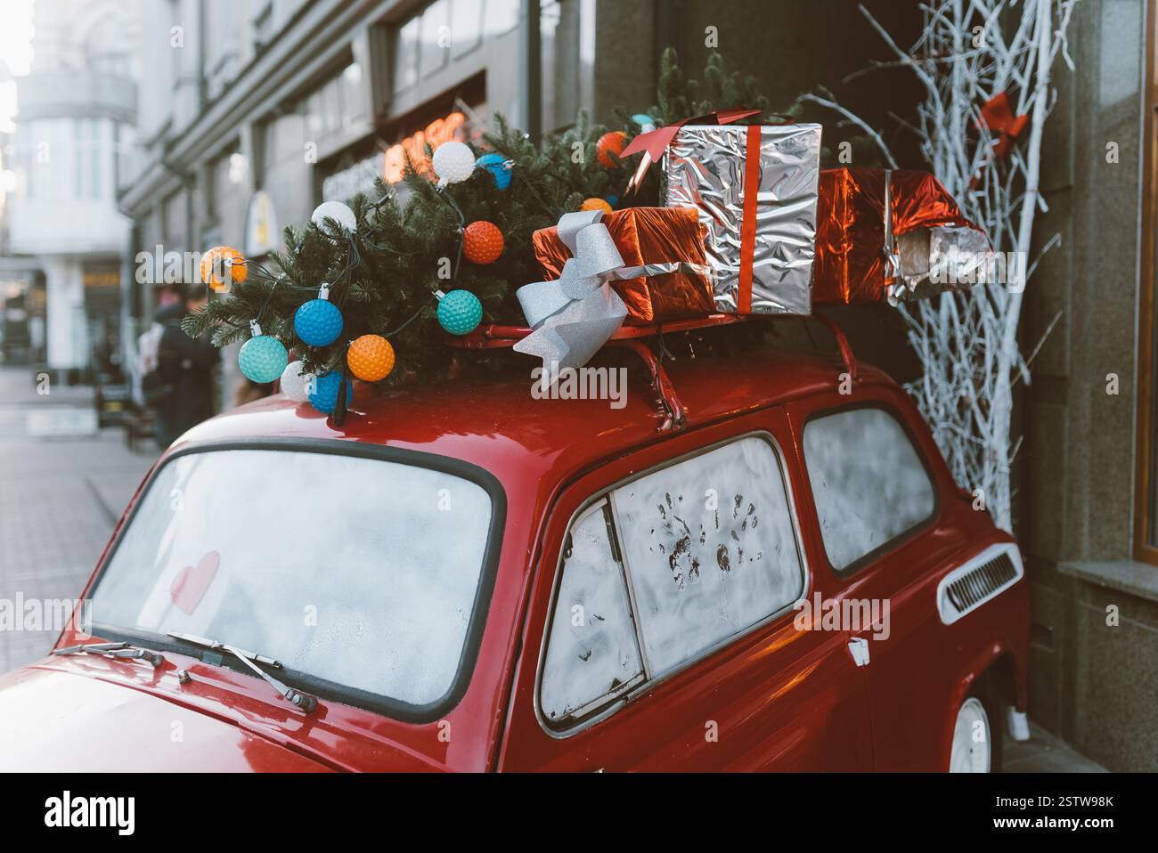 Red retro car with a Christmas tree fir tied to the roof Stock Photo ...