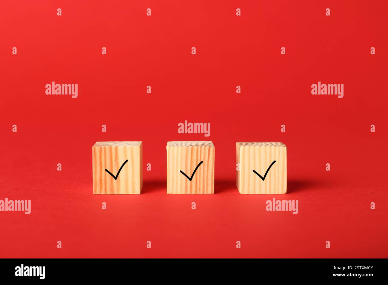 Wooden cubes with check marks on red background Stock Photo
