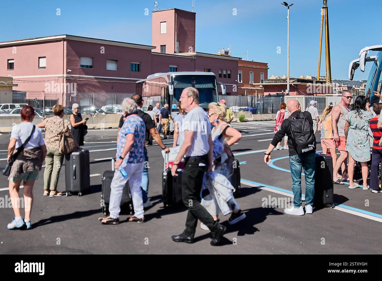Catania, Italy, February 20, 2025: Passengers with suitcases ready to board a bus at the bus station. Highlights the dynamic environment of a popular Stock Photo