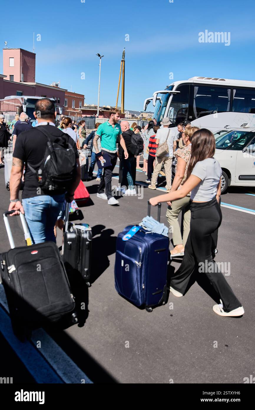 Catania, Italy - February 20, 2025: Bus station with travelers and their luggage. The image captures the excitement and energy associated with the jou Stock Photo