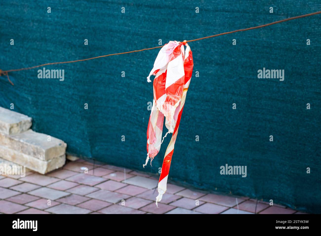 A vibrant red and white flag is gracefully hanging down from a wire ...