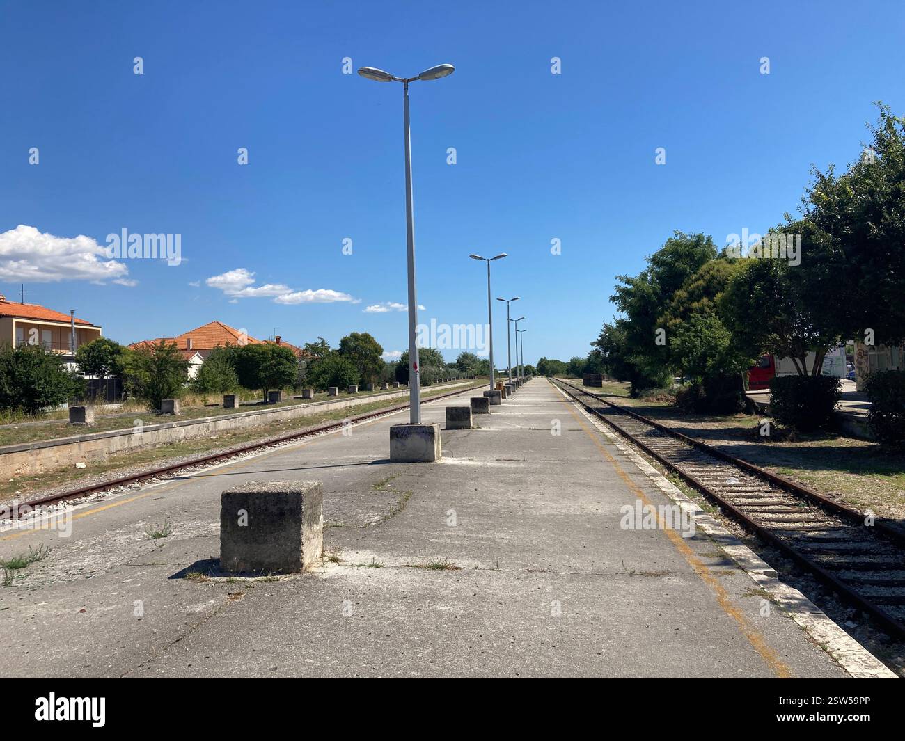 Abandoned railway station in Zadar, Croatia. Concrete building and railroad tracks with graffiti abandoned desolate ruin public transport by rail - Smartphone Captured Stock Image