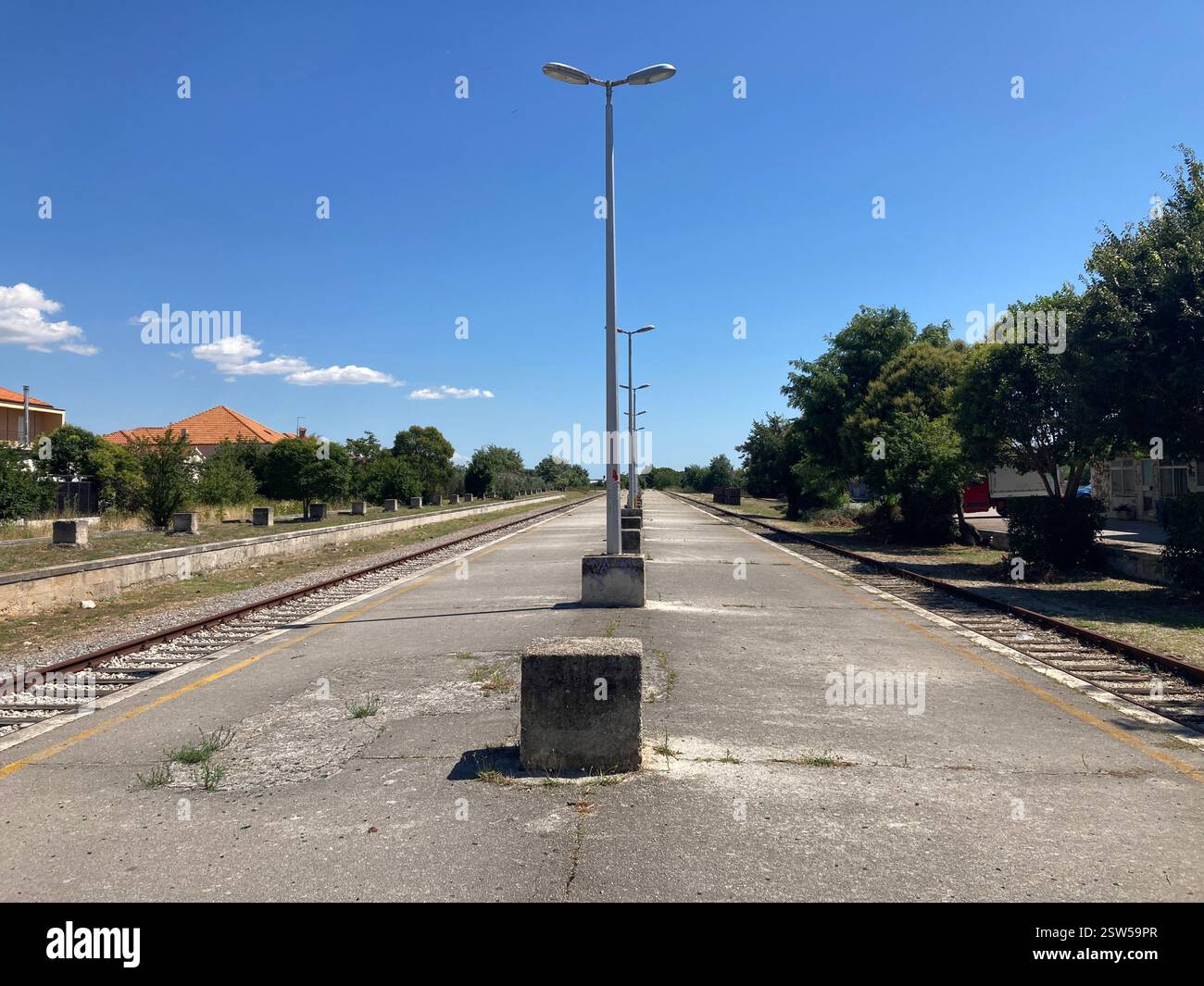 Abandoned railway station in Zadar, Croatia. Concrete building and railroad tracks with graffiti abandoned desolate ruin public transport by rail - Smartphone Captured Stock Image