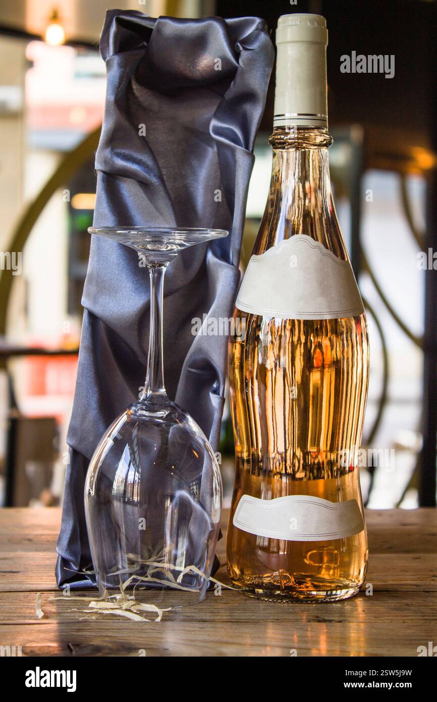 Manchester, United Kingdom, 2016: Elegant White Wine Bottle and Glasses on Rustic Wooden Table Stock Photo