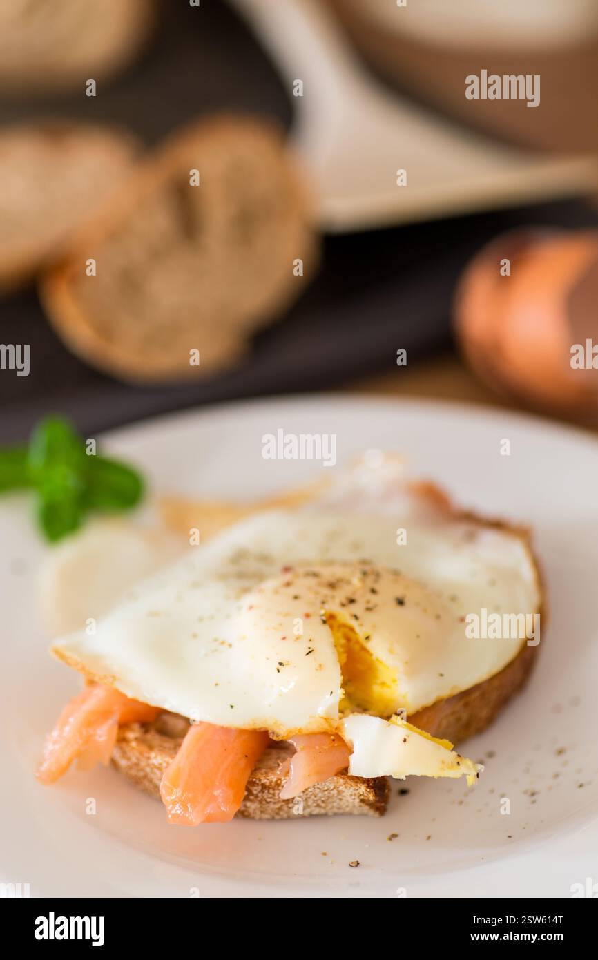 A slice of bread with lightly salted red fish and a cooked egg for breakfast. Stock Photo