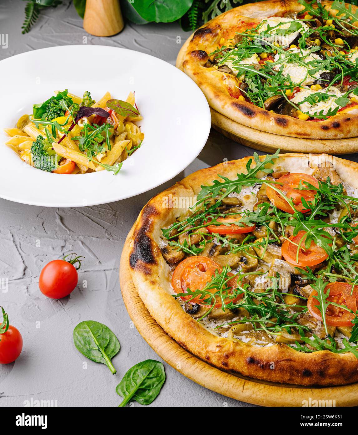 Fresh Toppings Artisanal pizzas with fresh toppings next to a plate of pasta, ready ...