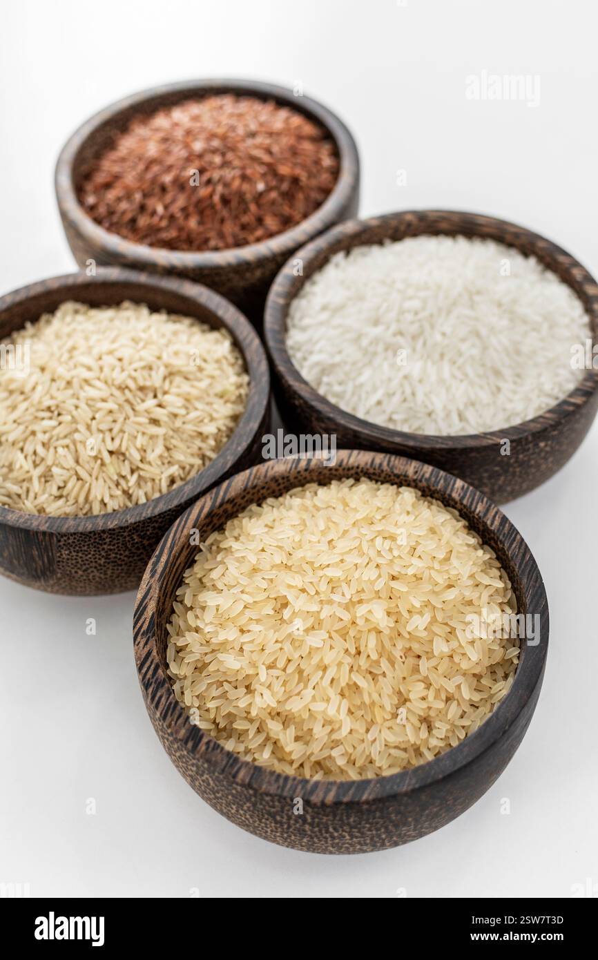 different kinds of asian rice grains in bowls on white background in ...