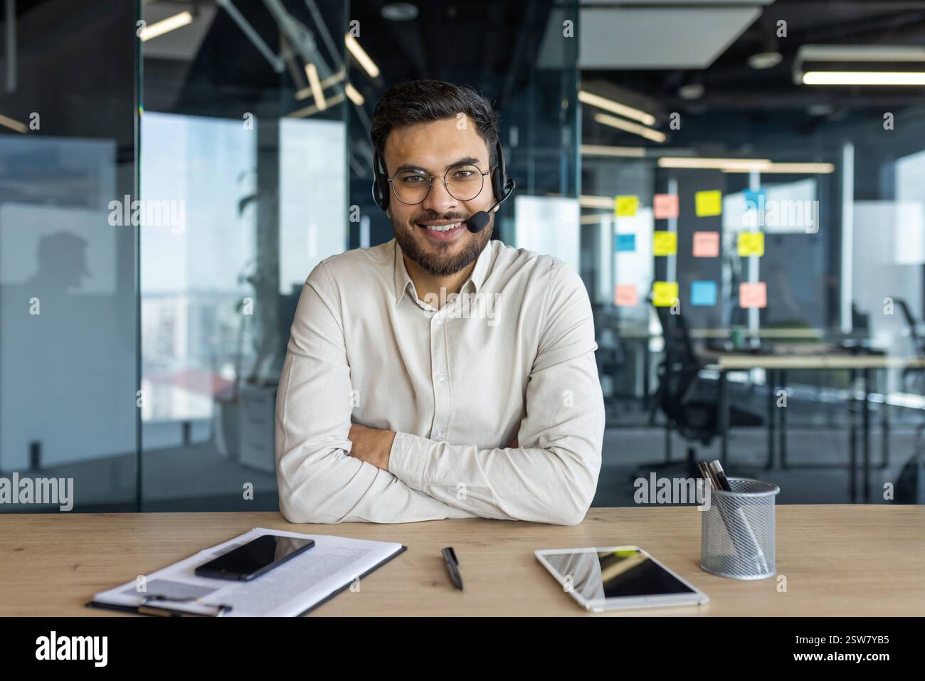 Webcam view, man with headset looking into camera, smiling contentedly ...