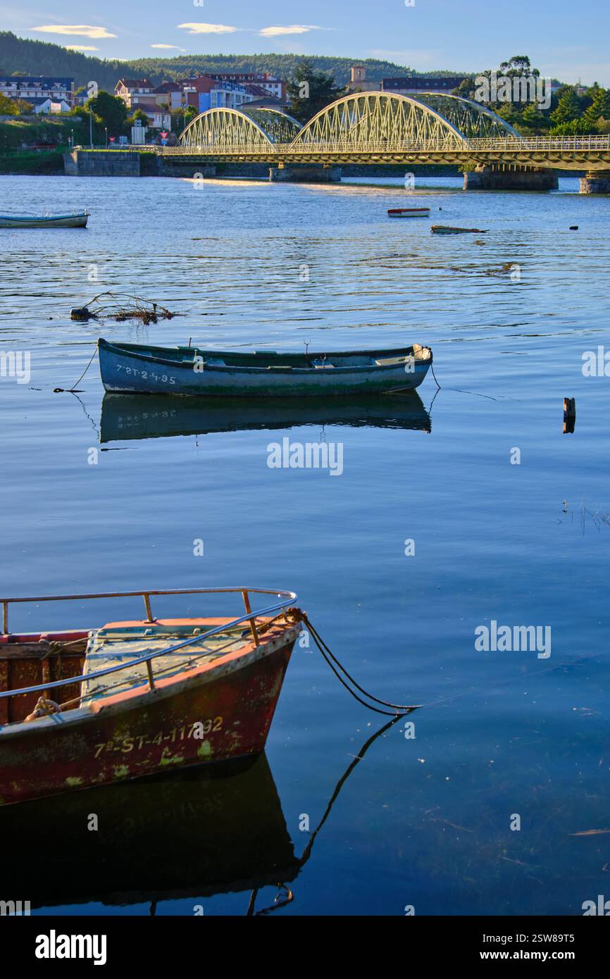 Tranquil river scene with boats and bridge Stock Photo