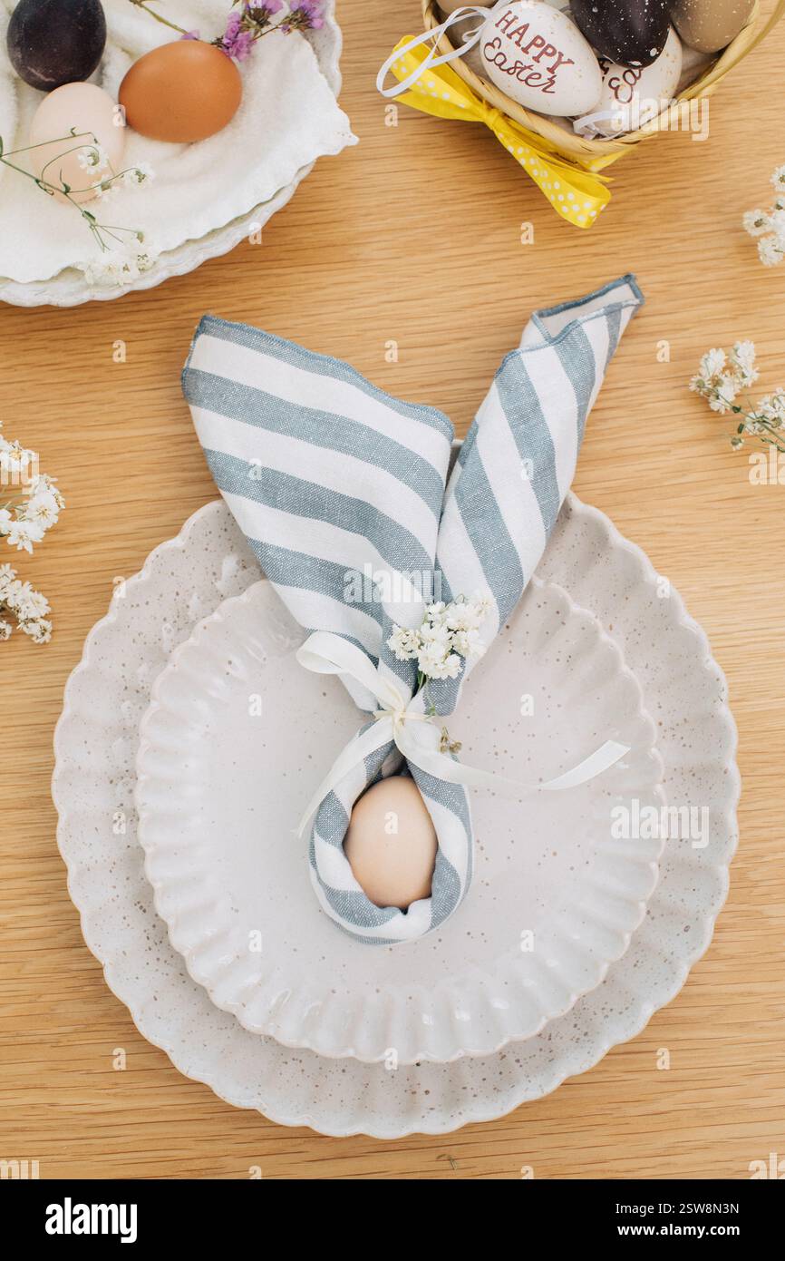 Easter egg wrapped in linen napkin in the shape of bunny with ears. Happy Easter  Stock Photo
