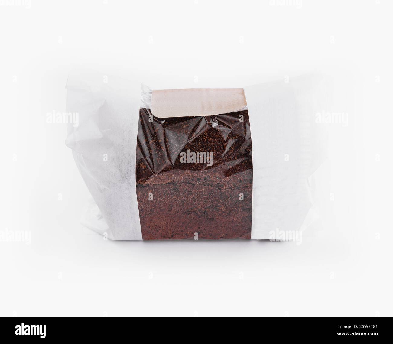 Freshly baked loaf of dark brown bread is wrapped in clear plastic and ...