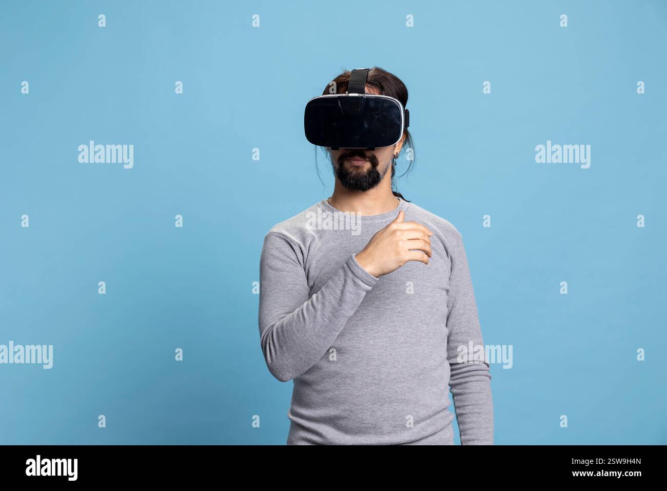 Trendy middle eastern guy using virtual reality headset on camera ...