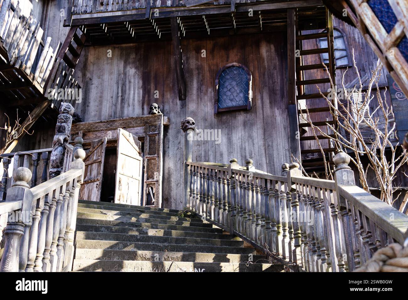 An eerie ghost house with dark wooden walls and haunting details, creating a mysterious and unsettling atmosphere. Stock Photo