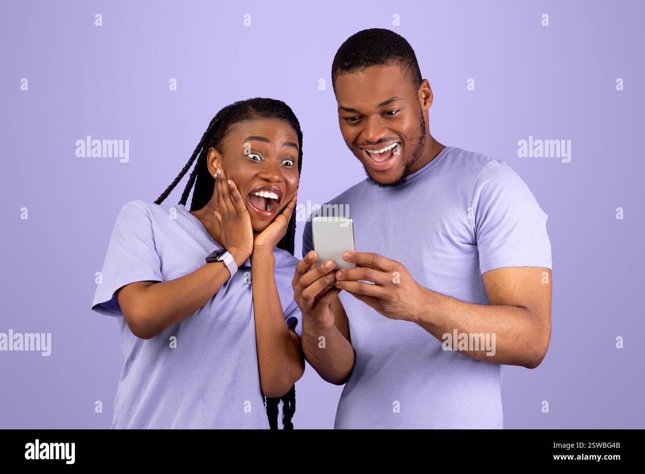 Portrait of surprised black couple using smartphone Stock Photo