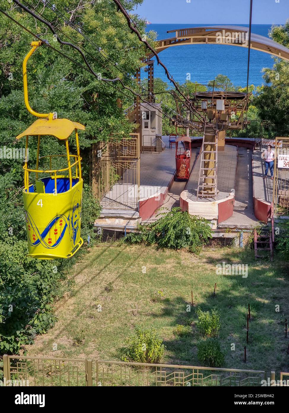 Colourful gondolas of the vintage Soviet cable car in Odesa / Odessa, Ukraine to Otrada beach near the lower station w/ view on Black Sea - Smartphone Captured Stock Image