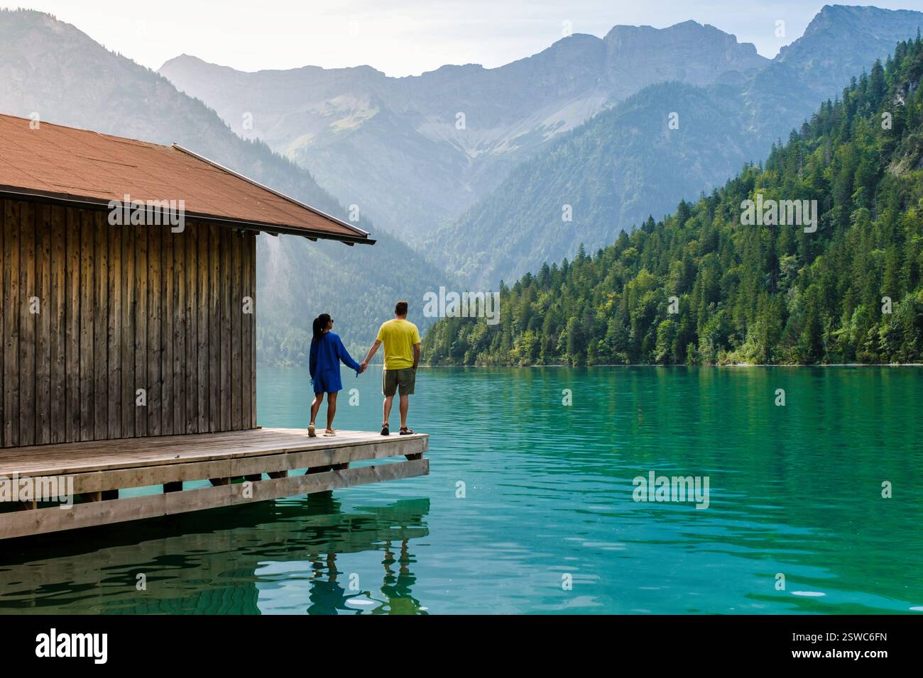 Couple enjoying a serene moment by the tranquil waters of Plansee in Austria Stock Photo