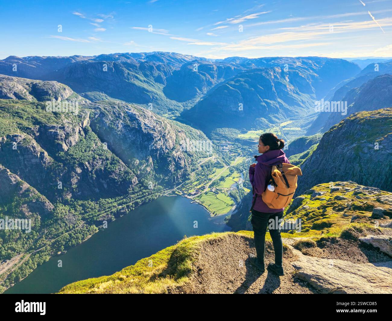 Surrounded by towering mountains and lush valleys woman with backpac hi ...