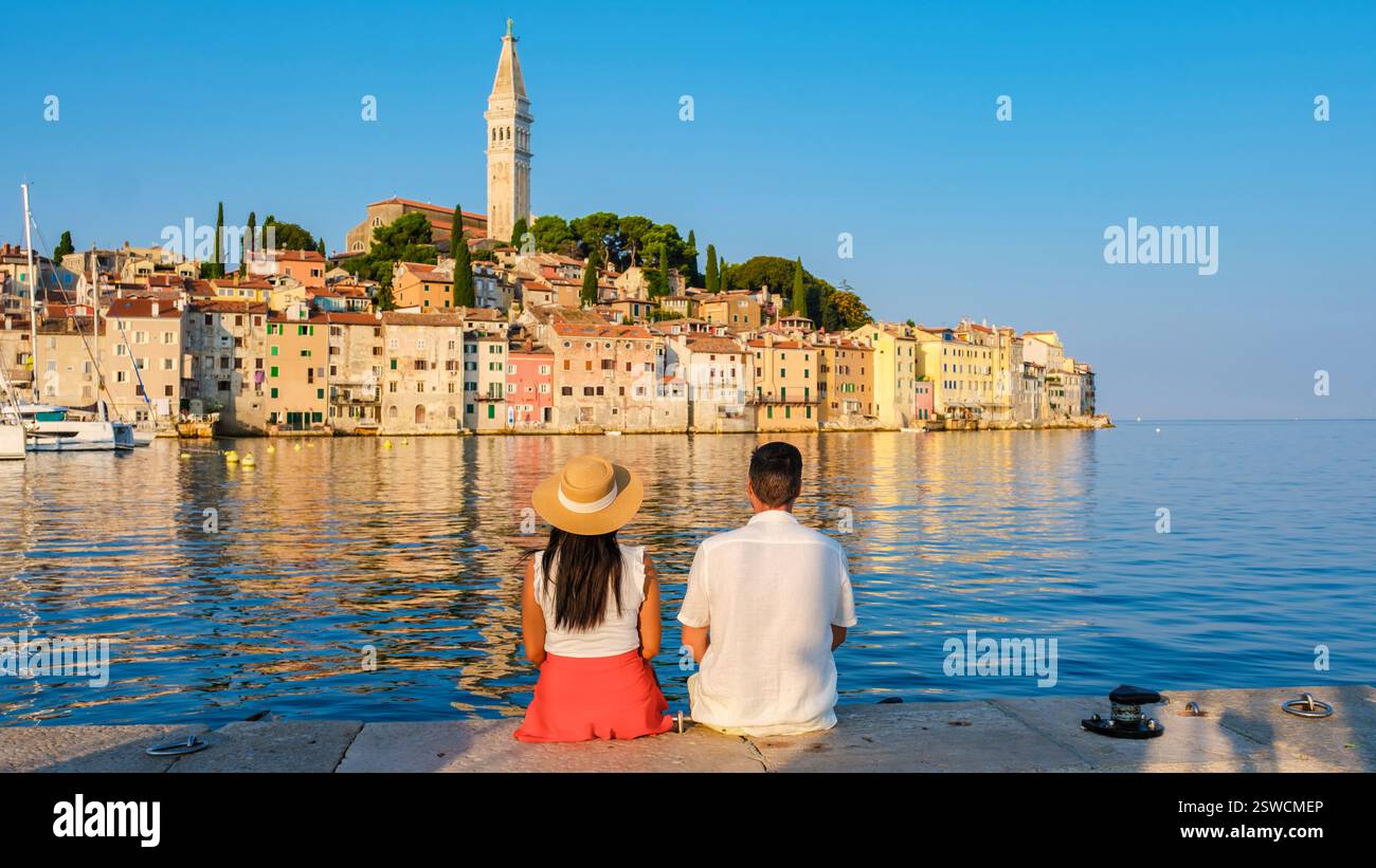 Couple enjoying a serene sunset by the waterfront in Rovinj, Croatia Stock Photo